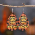 Detaillierte Nahaufnahme von herbstlichen Tropfen-Lederohrringen mit Kürbis-Motiv. - Stil 075