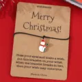 Detailansicht des Weihnachts-Wunscharmbands mit süßem Schneemann-Anhänger auf Kraftkarte. - SRY296-1