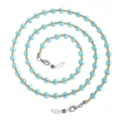 Close-up detail van blauwe glasparels brillenkettingen met gouden afstandhouders en lussen. - Blauw