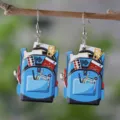 Detailed close-up view of school backpack wooden earrings featuring cute stationery pattern prints. - Colorful