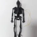 Gedetailleerd aanzicht van zwarte plastic skelet decoratie met koord voor feestjes. - 15cm Met Gesp / Zwart