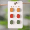 Bunte ovale Eier-Ohrstecker-Set mit drei Paaren in Orange, Rot und Grün auf Displaykarte. - Bunte Ovale Ei Ohrstecker Set (2172)