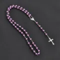 Detailed view of the purple imitation pearl rosary necklace with silver cross and medal. - Purple