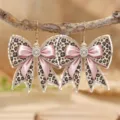 Primer plano detallado de pendientes colgantes con lazo estampado de leopardo y estrases. - Lazo Leopardo Strass (4720)