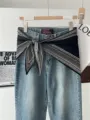 Detailed view of blue denim jeans decorated with a black paisley pattern triangle scarf. - Black Paisley with Border
