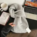 Vista detallada de bufanda de punto gris suave en mesa oscura con accesorios de estilo. - 160x22cm / Gris claro