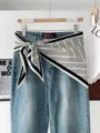 Blaue Jeanshose mit stilvollem schwarz-weiß gestreiften Schal als Taillen-Accessoire. - Dünne Linie Weiß