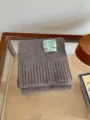 Acogedora bufanda de punto para invierno con ribete acanalado y etiqueta de marca elegante. - Moca