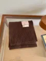 Gros plan détaillé d'un écharpe en tricot marron foncé confortable avec texture côtelée. - Café Foncé
