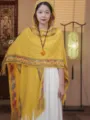 Detailed view of the yellow knitted hooded shawl with ethnic patterns and fringe design. - Yellow