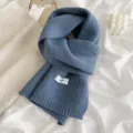 Gros plan sur l'écharpe en tricot bleu doux, mettant en valeur la texture et le style. - Aigue-marine