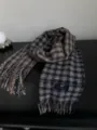 Primer plano detallado de una bufanda de invierno a cuadros azules y marrones con flecos. - Azul marino