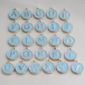 Close up of gold rim blue enamel round letter charms alphabet pendants diy jewelry making items - Light Blue