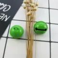 Nahaufnahme Detail von 22mm gelee lackierten Bastelglocken DIY Schmuckzubehör auf Gitter - Grün