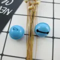 Close-up of 22mm jelly blue painted jingle bells, ideal for DIY jewelry crafting. - Aqua