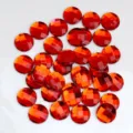 Detailaufnahme von 14mm flachen runden Gitter facettierten orange Acryl Strass Bastelsteinen. - 14mm / Rot