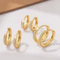 Gedetailleerd overzicht van kleine gouden créoles met sprankelende zirkoniasteentjes, elegant. - Set van 3 Paren / Goud