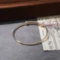 Minimalist gold adjustable wire bangle, elegant metal minimalist fashion bracelet detail. - Gold