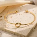 Verzamelde open manchetarmband met stijlvol knoopontwerp en baluiteinden, elegante sieraden. - Goud
