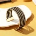 Close-up detail van een stijlvolle meerlaagse kraal armband in zwart-gouden afwerking. - Effen Kleur 7 / Goud
