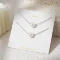 Gedetailleerde close-up van dubbellaagse parelketting ketting op witte displaykaart - Dubbellaagse Parel Stijl