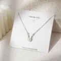 Gedetailleerde close-up van de prachtige hertenantennepareketting op een witte kartonnen display. - Geweivorm