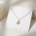 Close-up detail van zilveren margriet hanger halsketting met parel en strass op displaykaart. - Madeliefjesstijl