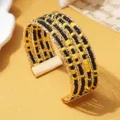 Meerlaagse kralen manchetarmband met zwarte en gele kralen op gouden draad. - Tweekleurig 10 / Goud
