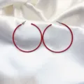 Detail van rode creoolse oren, minimalistisch metalen cirkel design voor dagelijkse mode. - Rood
