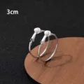 Close-up detail van zilveren creolen met veilige clip-on sluiting op een houten standaard. - Clip-On Earrings / 3cm / Zilver
