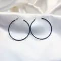 Elegante grote zwarte creolen oorbellen met gladde afwerking, perfect voor dagelijkse mode looks. - Zwart