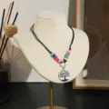 Gedetailleerde close-up van de handgemaakte kleurrijke kleikralen ketting met ronde boomhanger. - Boom (Stijl 5)