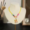 Gedetailleerd overzicht van kleurrijke kleikralen kinderketting met schattige gele konijnenhanger. - Geel Konijn (Stijl 8)