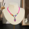 Gedetailleerd opname van kleurrijke kleikralen ketting met hamsa hand hanger voor kids. - Hamsa Hand Boze Oog (Stijl 13)