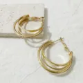 Gedetailleerde close-upopname van de elegante stijlvolle meerlaagse gouden creolen met glans. - Stijl 5 Goud
