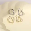 Gedetailleerde close-up van stijlvolle onregelmatige geometrische metalen oorringen. - Onregelmatige Geometrische Ring (Nr. 8)