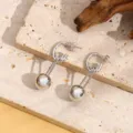 Gedetailleerde close-up van moderne zilverkleurige oorbellen met een strak bolontwerp. - A003 Stijl / Witgoud