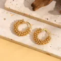 Detailopname van trendy gouden metalen kralen-oorringen met uniek getextureerd bubbeldesign. - Stijl A008 / Goud