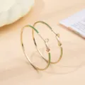 Elegante gouden creolen met levendig groen emaille, chic modern ontwerp voor vrouwen. - Goud + Groen