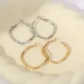 Gedetailleerde close-up van geometrische dubbellaagse metalen oorbellen in zilver. - Oorbellen 6 / Zilver