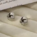 Elegantes pendientes de botón con nudo espiral de metal, diseño geométrico moderno. - Pendientes de espiral estilo Q - Oro blanco