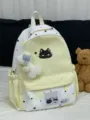 Detailed view of cute yellow and white star canvas backpack with black cat graphic and plush pendant. - Bow Bone Pendant / Yellow