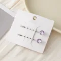 Detailansicht einfacher lila Kristall Metall Haarklammern auf weißer Karte, Accessoire. - Lila