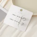 Gros plan de pinces à cheveux en métal avec des motifs de planète et de cœur en zircon sur carte. - Blanc Étoilé