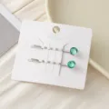 Elegante silberne Haarnadeln mit funkelnden türkisen Kristall-Strasssteinen auf Karte. - Pfauenblau