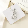 Close-up detail of sparkling crystal flower hair clips on white card, shining side clip decor. - Oval Rhinestone Flower White
