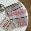 Detailed view of soft pink and grey plaid winter scarf with elegant fringe and cozy warm texture. - Pink - Wool