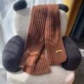 Cozy brown knitted winter scarf with ribbed texture and handmade label detail, casual warmth. - 6