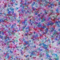 Primer plano detallado de cuentas de vidrio aurora coloridas, ideal para manualidades de resina. - Multicolor