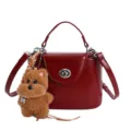 Wine red leather box handbag with cute dog charm, stylish top handle crossbody bag for women. - Red
